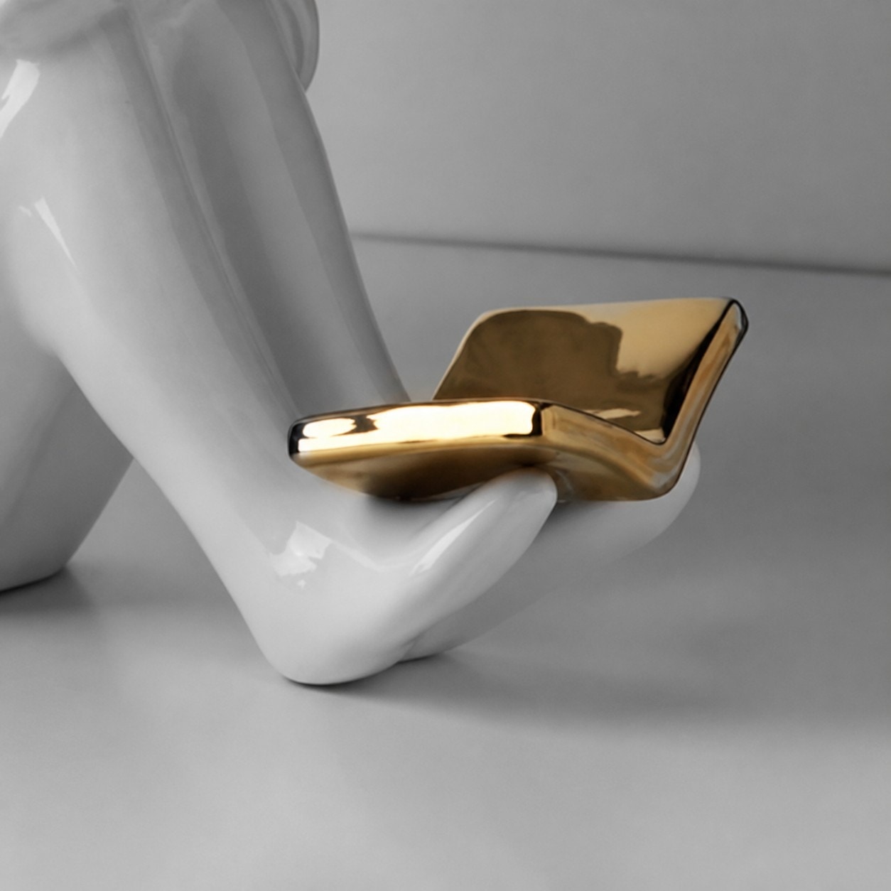 Gold-tone book rest detail on ceramic figure bookend