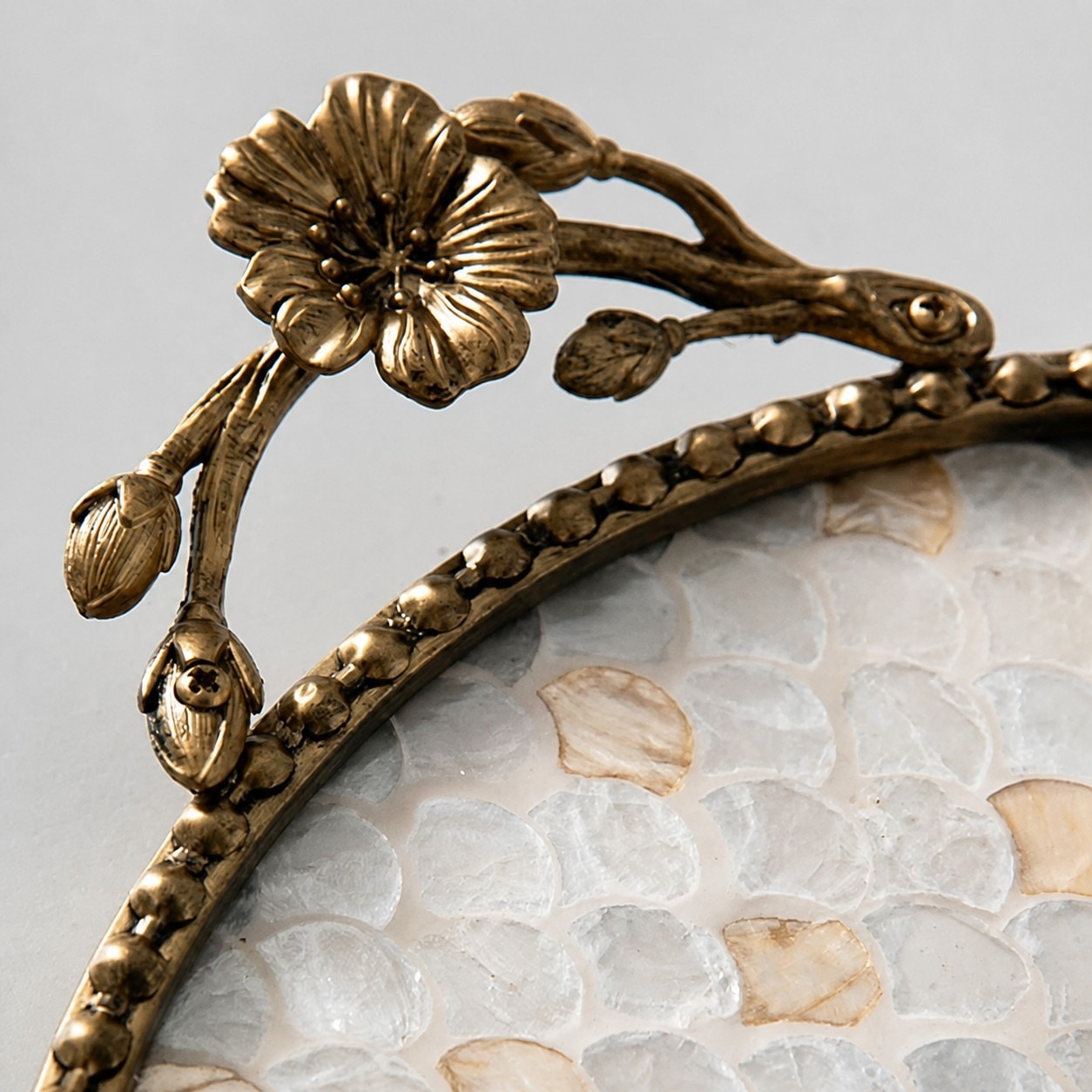 Antique brass floral handle detail on shell inlay tray