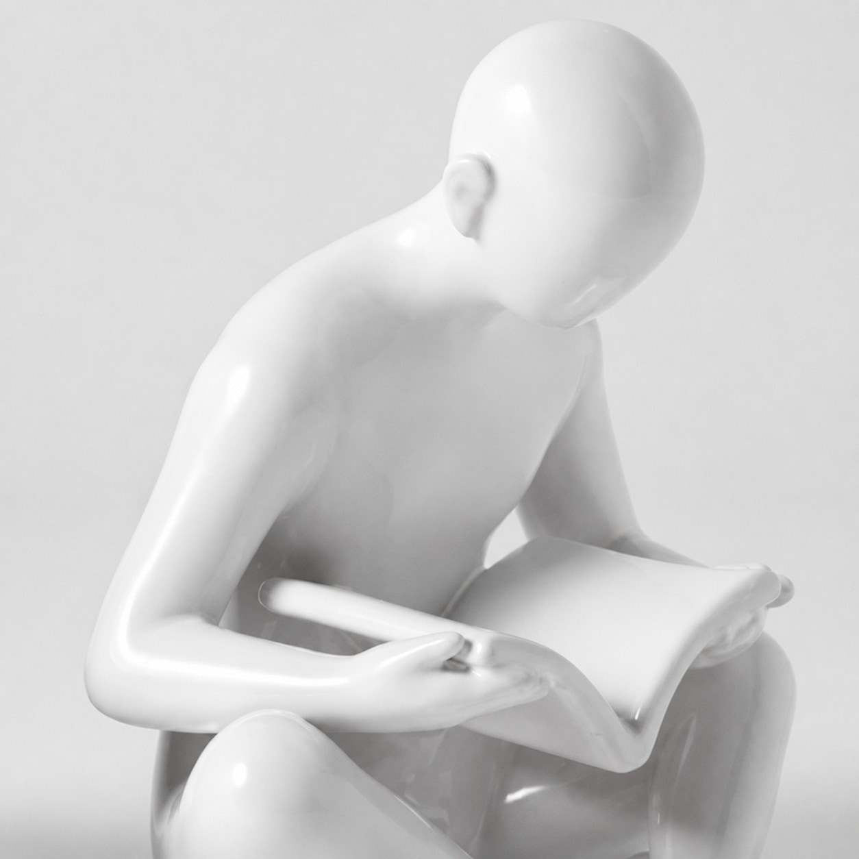 Detalle de una figura de lectura de cerámica blanca brillante